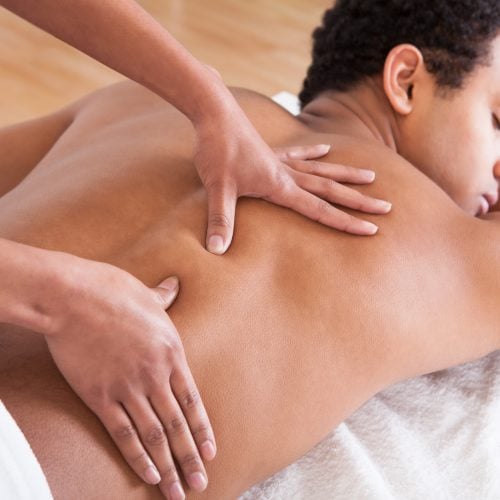 Portrait Of Man Receiving Massage Treatment From Female Hand